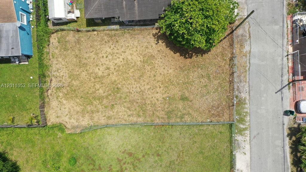 An aerial view shows a vacant, fenced rectangular lot situated between two residential properties — 2455 NW 55th street, Miami FL 33142, MIAMI, FL