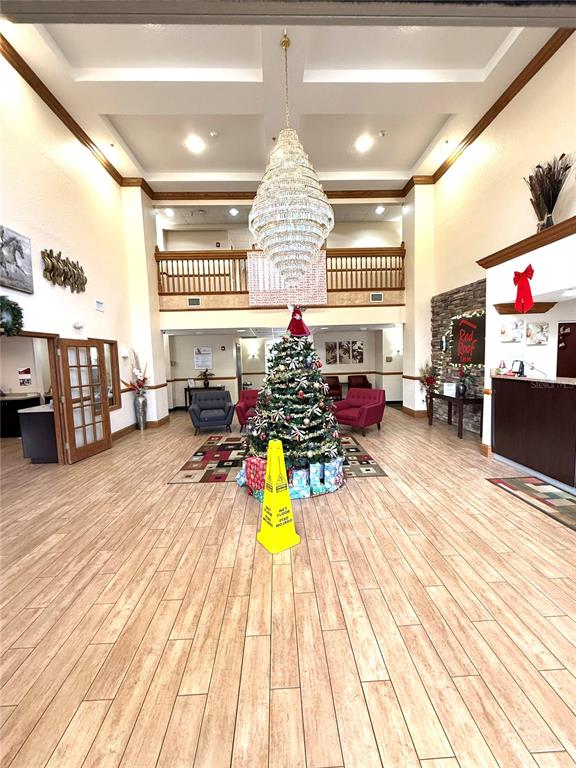 A hotel lobby features a large chandelier, a decorated Christmas tree, and wood-look flooring — 120 NW 40TH AVENUE, OCALA, FL