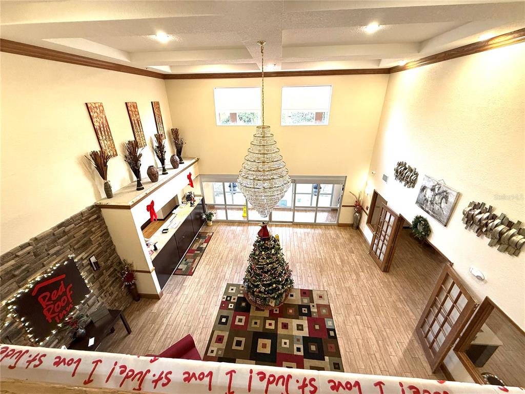 A high-angle view of a hotel lobby featuring a large chandelier, Christmas tree, and reception desk — 120 NW 40TH AVENUE, OCALA, FL