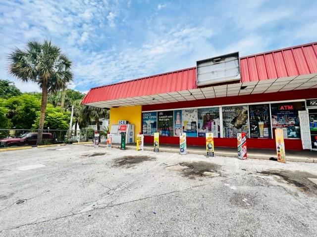 A red-roofed commercial building features a large parking lot and several storefront display windows — 223 E VOORHIS AVENUE, DELAND, FL
