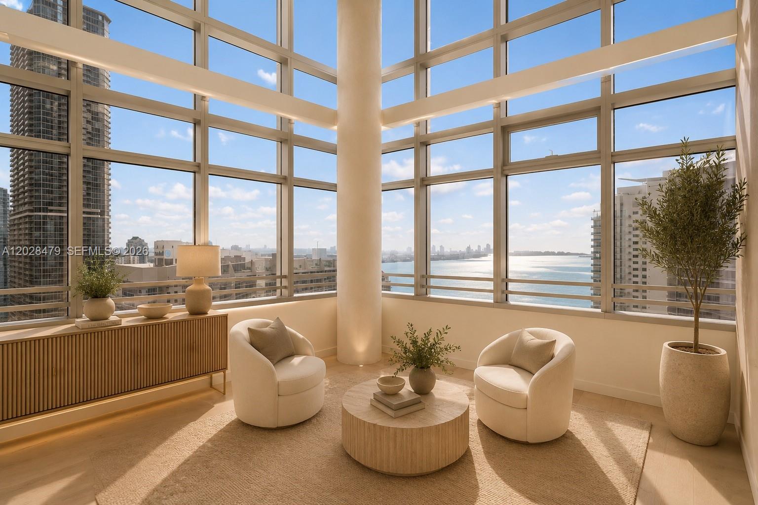 A sunlit corner room features floor-to-ceiling windows, two cream armchairs, and a round coffee table — 1395 Brickell Ave # 3410, Miami FL 33131, MIAMI, FL