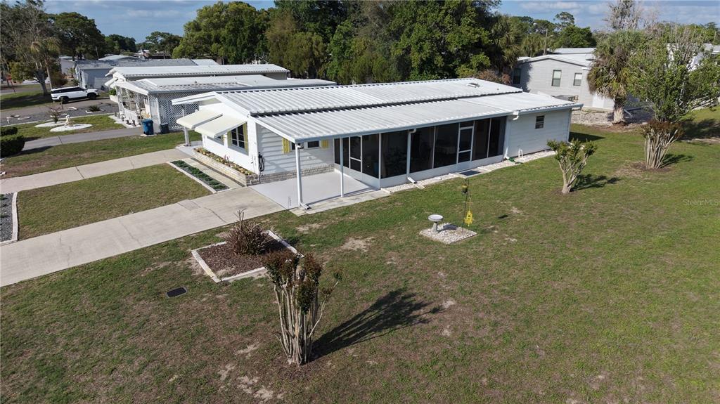 An aerial view of a white mobile home with a metal roof and screened porch — 7338 THORPP AVENUE, BROOKSVILLE, FL