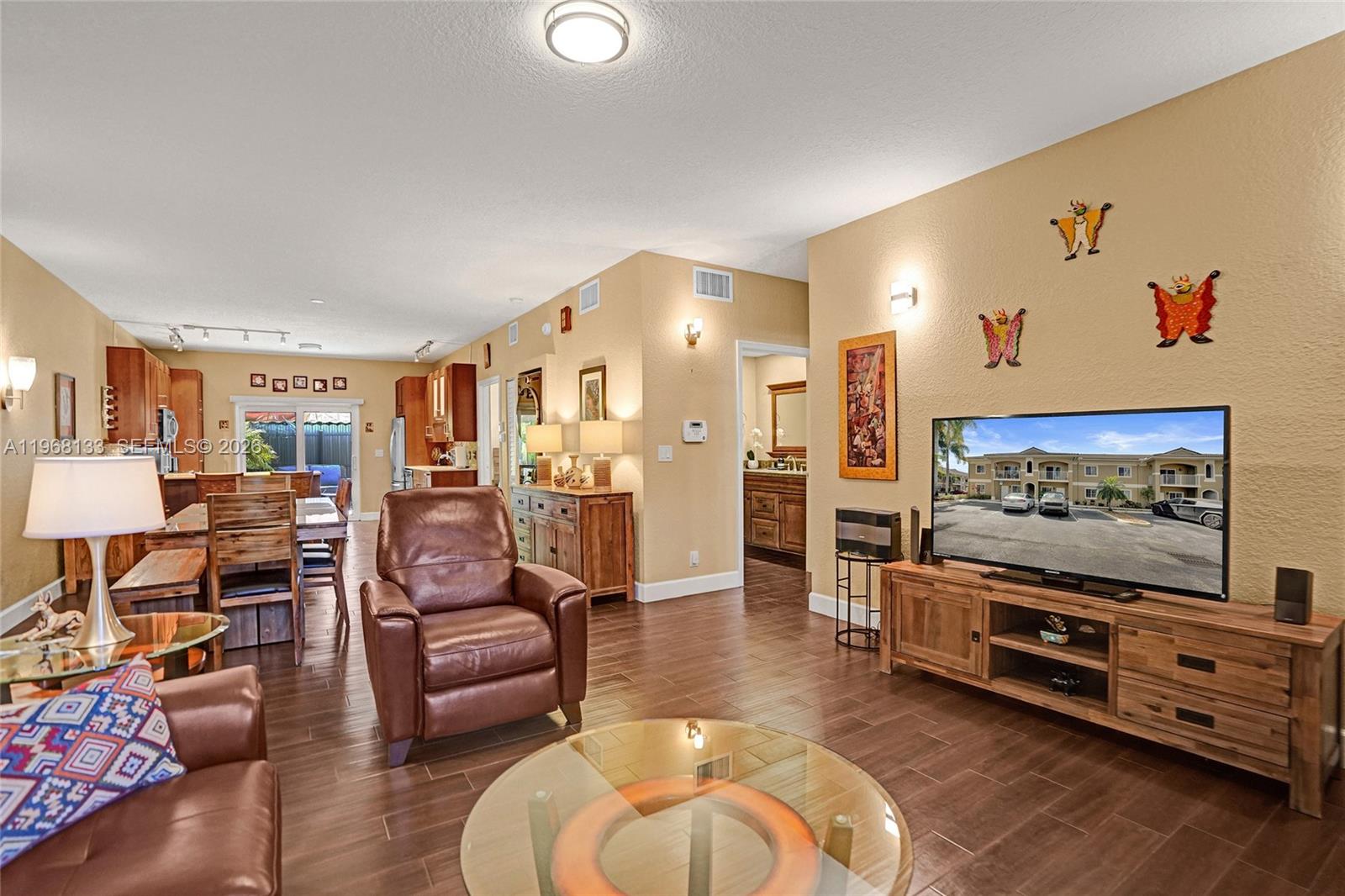 A living room with tile flooring, a leather recliner, and a television on a wooden stand — 4812 Washington St # 3, Hollywood FL 33021, HOLLYWOOD, FL