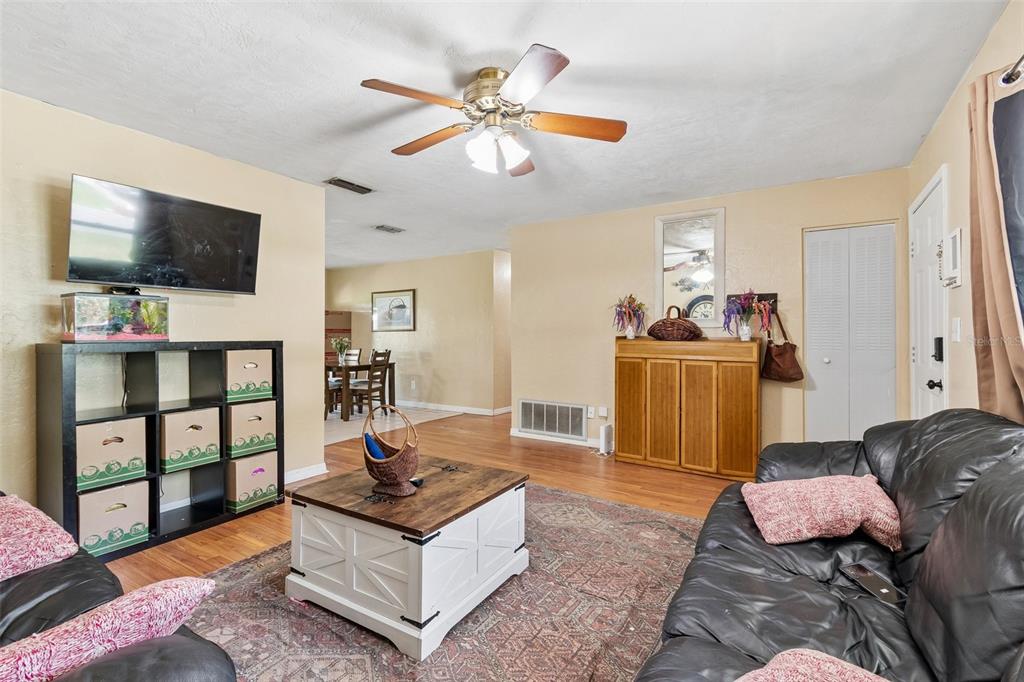 A living room features a black leather sofa, a white coffee table, and a storage unit — 5934 NW 30TH TERRACE, GAINESVILLE, FL