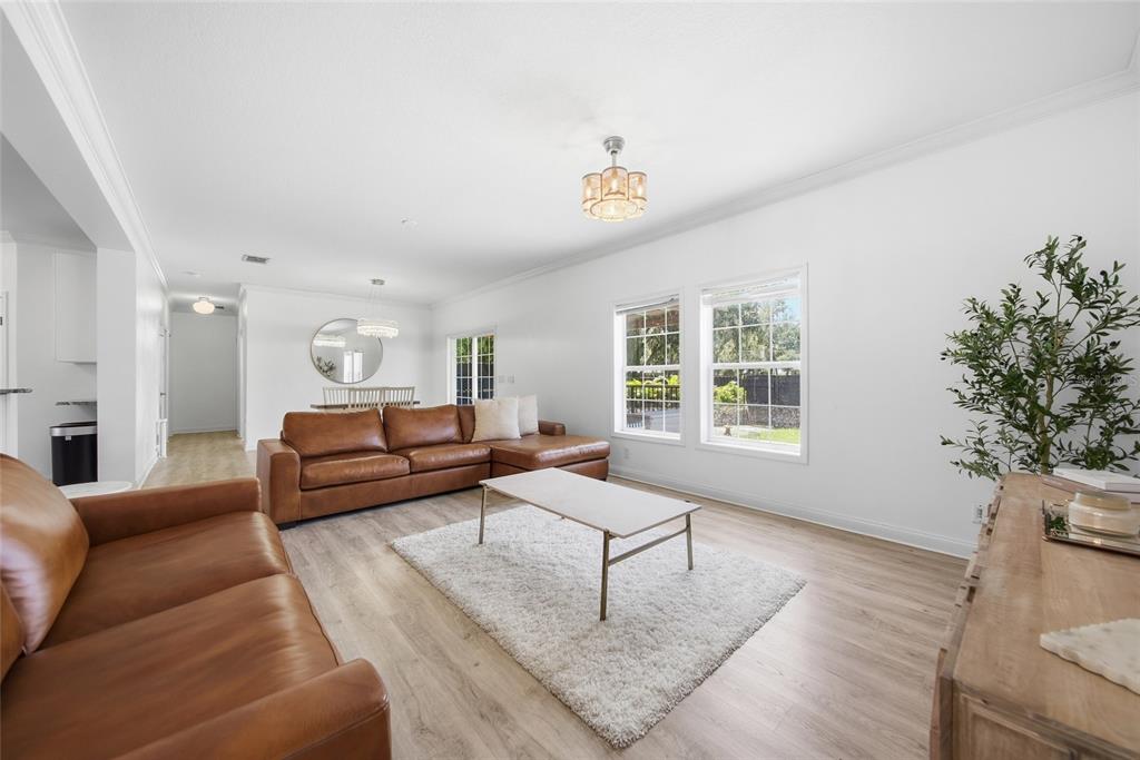 A living room features light wood flooring, a brown leather sectional, and a white rug — 5335 SHAKESPEARE DRIVE, DOVER, FL