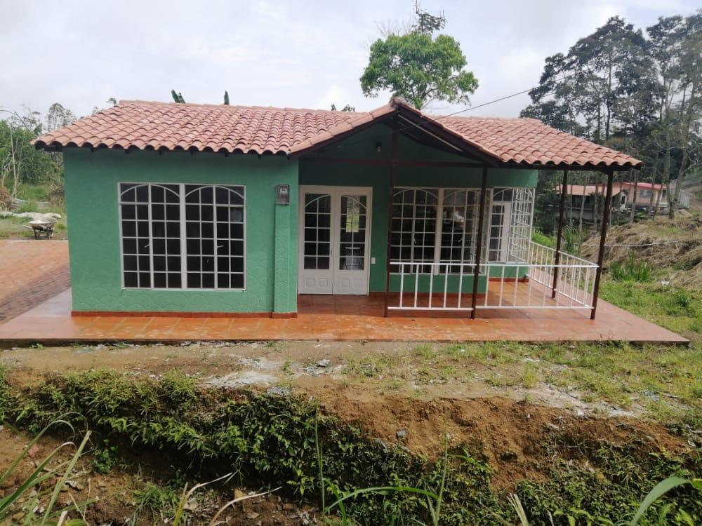 A green one-story house with a tiled roof and a covered front porch — Colombia El Hatillo, Mariquita, Tol, Co, FL