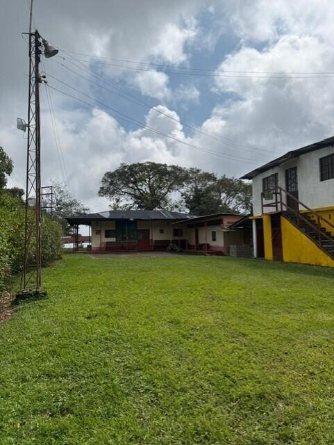 A grassy yard leads to a single-story building and a two-story structure with stairs — Colombia El Hatillo, Mariquita, Tol, Co, FL
