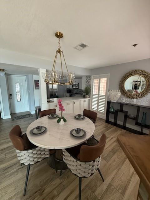 A dining area features a round marble table, woven chairs, and a gold chandelier — 1020 E MICHIGAN STREET UNIT 1020, ORLANDO, FL