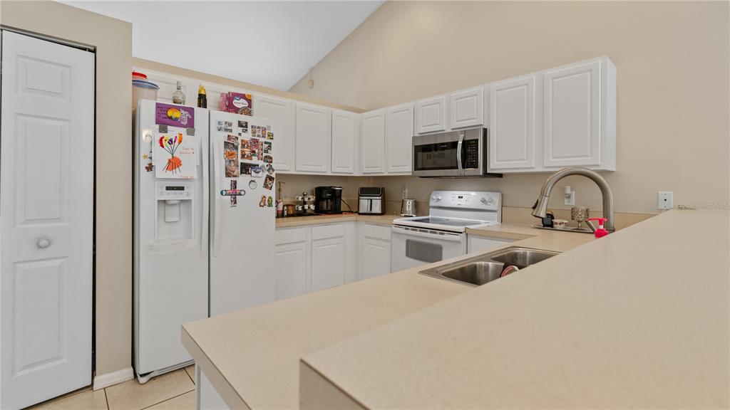 A kitchen with white cabinets, stainless steel appliances, and a breakfast bar countertop — 2001 SW FEARS AVENUE, PORT ST LUCIE, FL