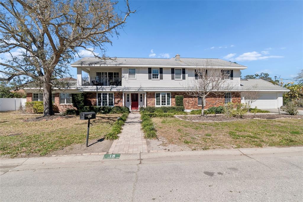 A two-story house with a brick and siding exterior, a balcony, and a paved walkway — 19 SANDPIPER ROAD, TAMPA, FL