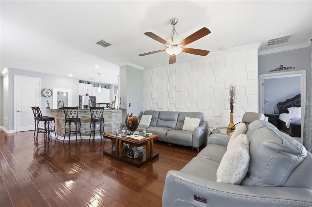 A formal dining room features a stone-topped table, dark leather chairs, and hardwood flooring — 4020 CARTERET DRIVE, WINTER HAVEN, FL
