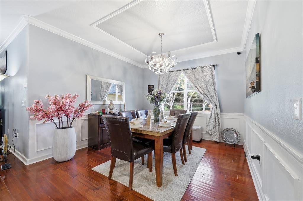 A living room with wood floors, a textured white wall, and a kitchen breakfast bar — 4020 CARTERET DRIVE, WINTER HAVEN, FL