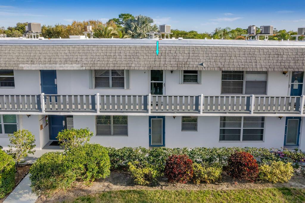 An exterior view of a two-story apartment building with a balcony and a shingled roof — 2929 SE Ocean Boulevard # 8, Stuart FL 34996, STUART, FL