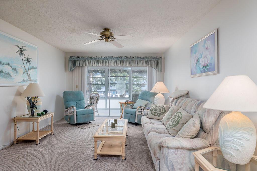 A living room features a sofa, two blue recliners, a coffee table, and sliding glass doors — 2929 SE Ocean Boulevard # 8, Stuart FL 34996, STUART, FL