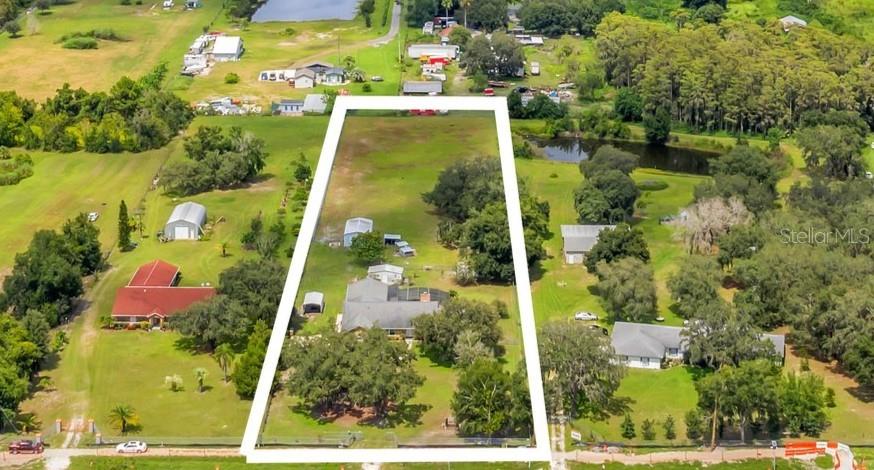 An aerial view shows a large, rectangular residential lot outlined in white with several buildings — 4147 BOGGY CREEK ROAD, KISSIMMEE, FL