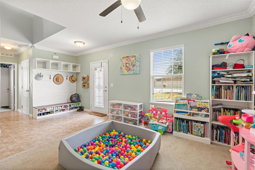 A playroom features a ball pit, a bookshelf, a storage bench, and a ceiling fan — 841 JEFFERSON BOULEVARD, HAINES CITY, FL