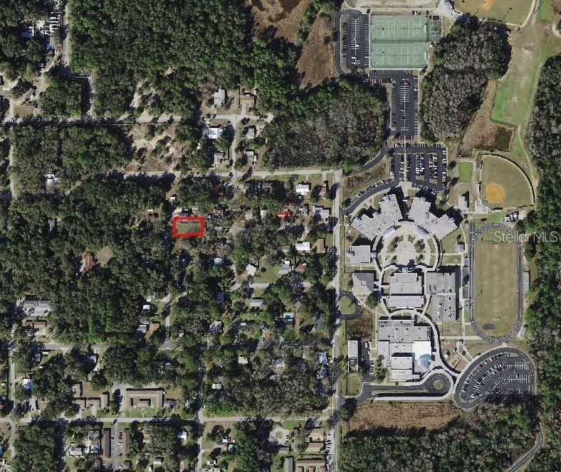 This is an aerial map showing a residential lot outlined in red near a school — 1189 NE 6TH COURT, CRYSTAL RIVER, FL