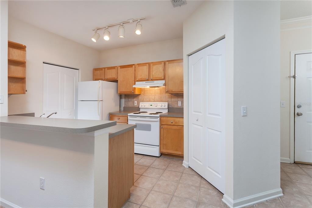 A kitchen features light wood cabinets, white appliances, a breakfast bar, and tile flooring — 4207 S DALE MABRY HIGHWAY UNIT 10308, TAMPA, FL