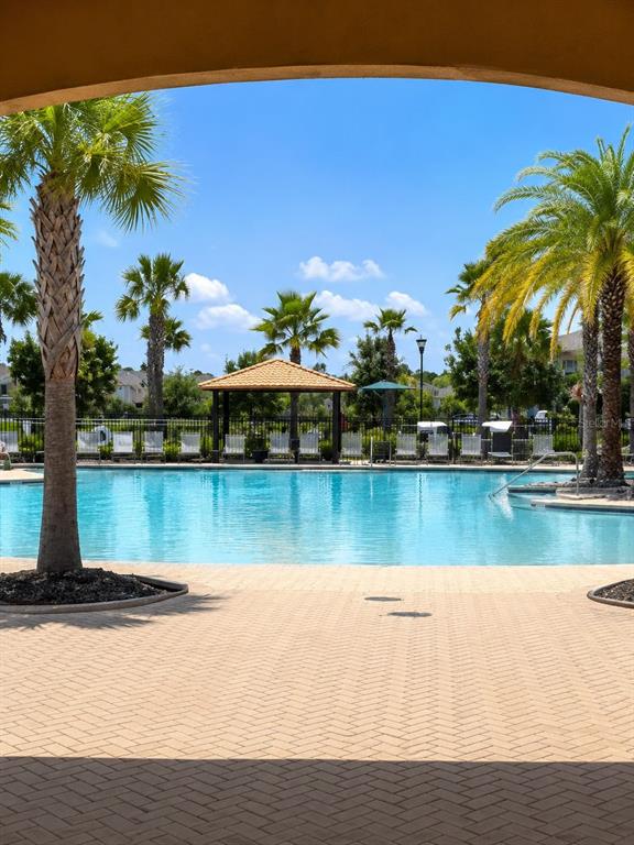 A single-story house with a tan stucco exterior, a two-car garage, and a paved driveway — 2608 NOUVEAU WAY, KISSIMMEE, FL
