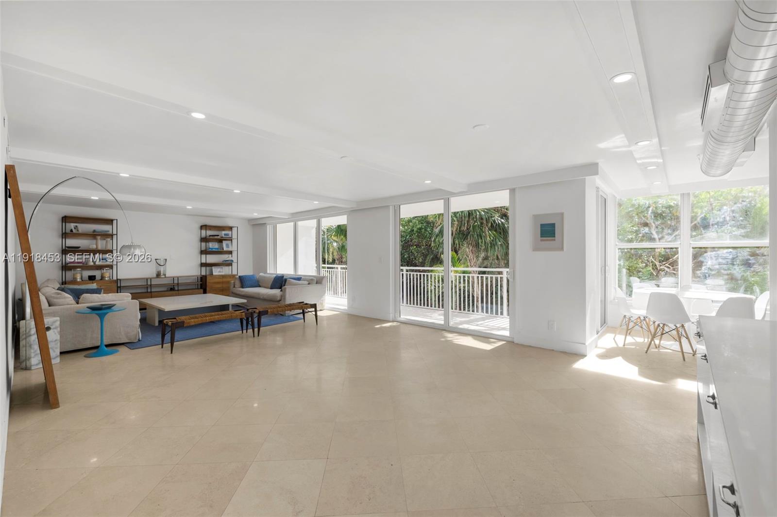 A bright, open-concept living and dining area features white walls, tile floors, and balcony access — 605 Ocean Dr # 2L, Key Biscayne FL 33149, KEY BISCAYNE, FL