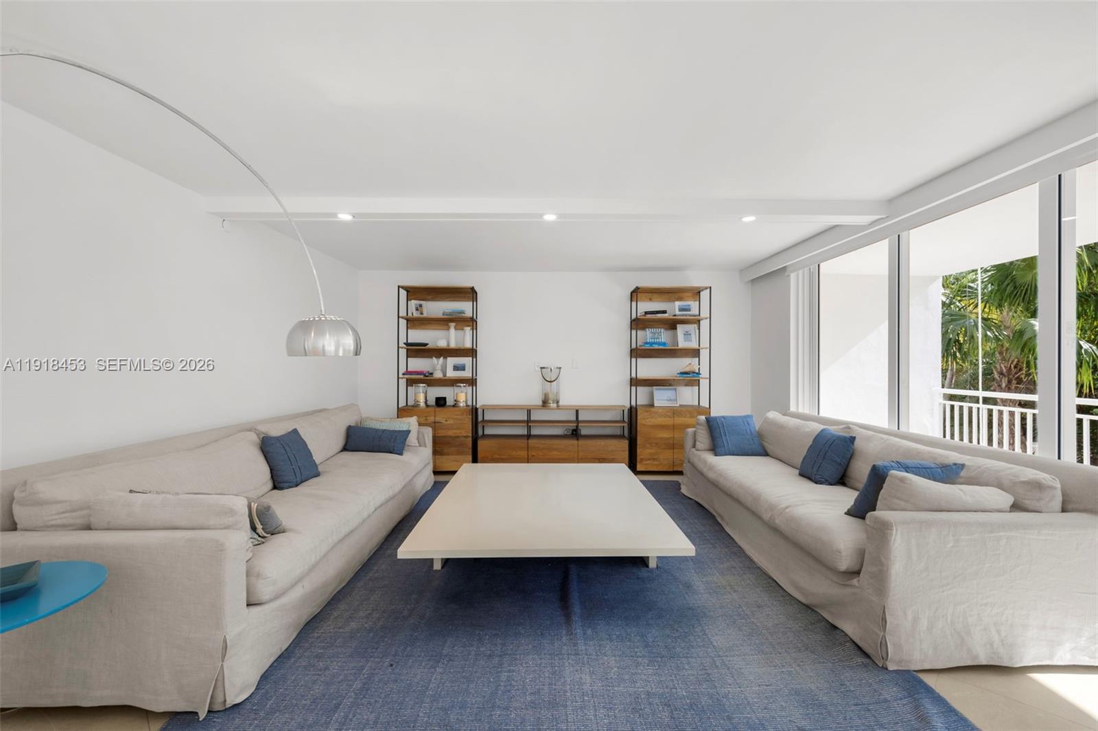A living room features two beige sofas, a large white coffee table, and wooden shelving — 605 Ocean Dr # 2L, Key Biscayne FL 33149, KEY BISCAYNE, FL
