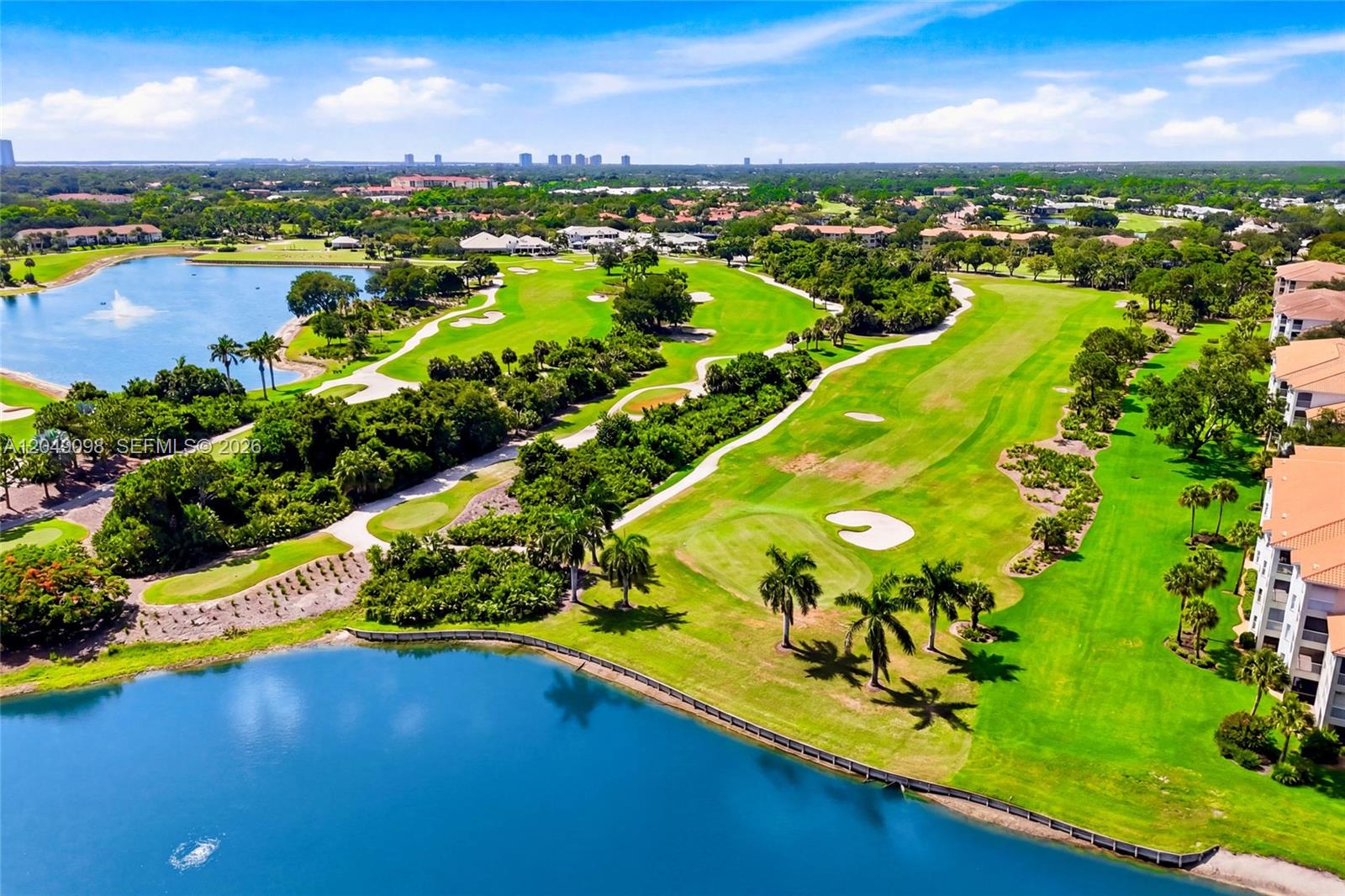 An aerial view of a golf course with a lake and residential buildings — BONITA SPRINGS, FL