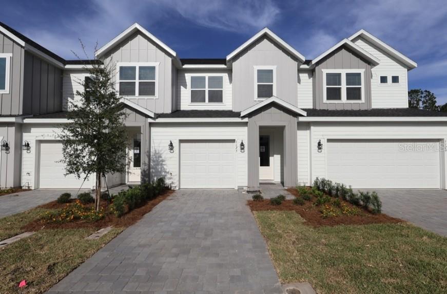 A modern kitchen with white cabinets, stainless steel appliances, and an island with a sink — 1125 WILD CREST LANE, DAYTONA BEACH, FL