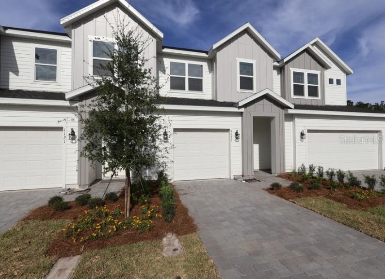 A modern kitchen features white cabinets, stainless steel appliances, and a white countertop island — 1125 WILD CREST LANE, DAYTONA BEACH, FL