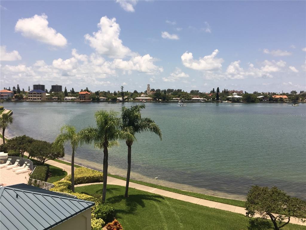 An elevated view of a waterfront property featuring palm trees, a lawn, and a bay — 7974 SAILBOAT KEY BOULEVARD S UNIT 701, SOUTH PASADENA, FL