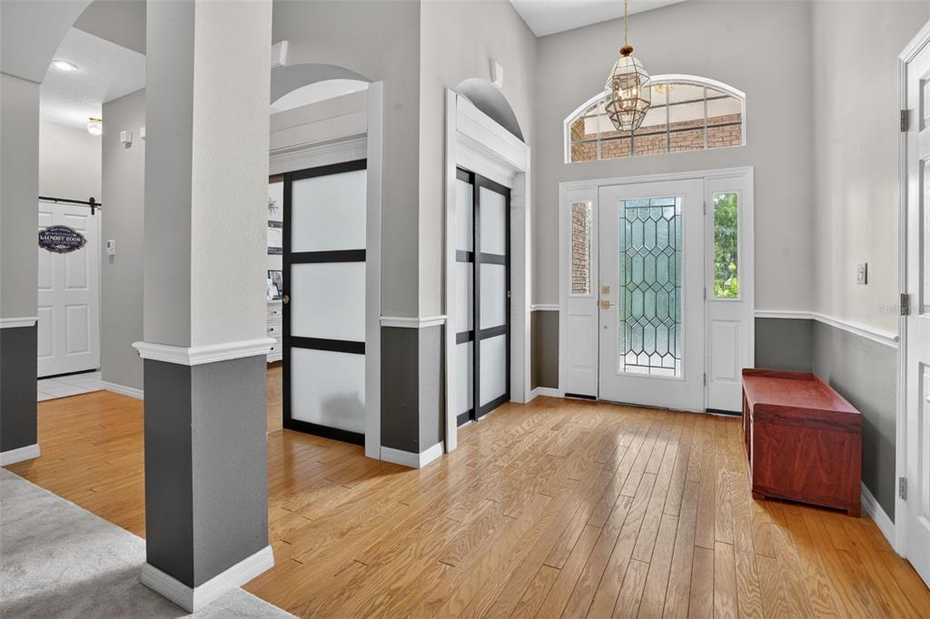 A dining area with a wooden table and chairs sits on carpeted flooring near glass doors — 9363 TOOKE SHORE DRIVE, WEEKI WACHEE, FL