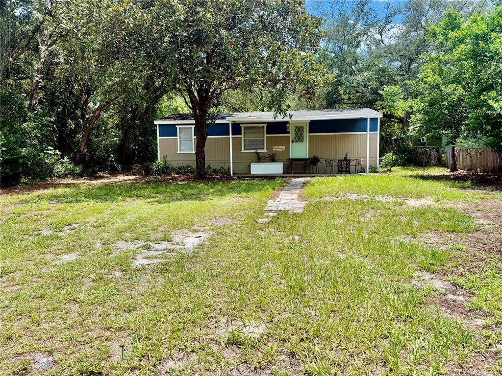 A single-story mobile home with tan and blue siding sits on a grassy lot — 31638 LAKE DRIVE, EUSTIS, FL
