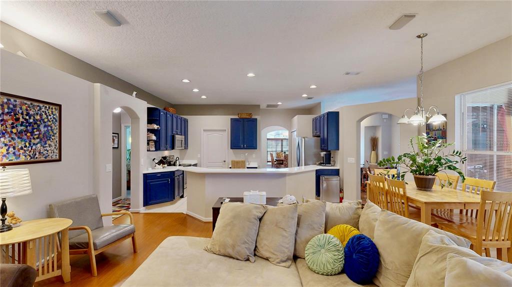 A kitchen features blue cabinets, stainless steel appliances, a white countertop, and a built-in desk — 9101 WOODBRIDGE OAK TERRACE, ORLANDO, FL
