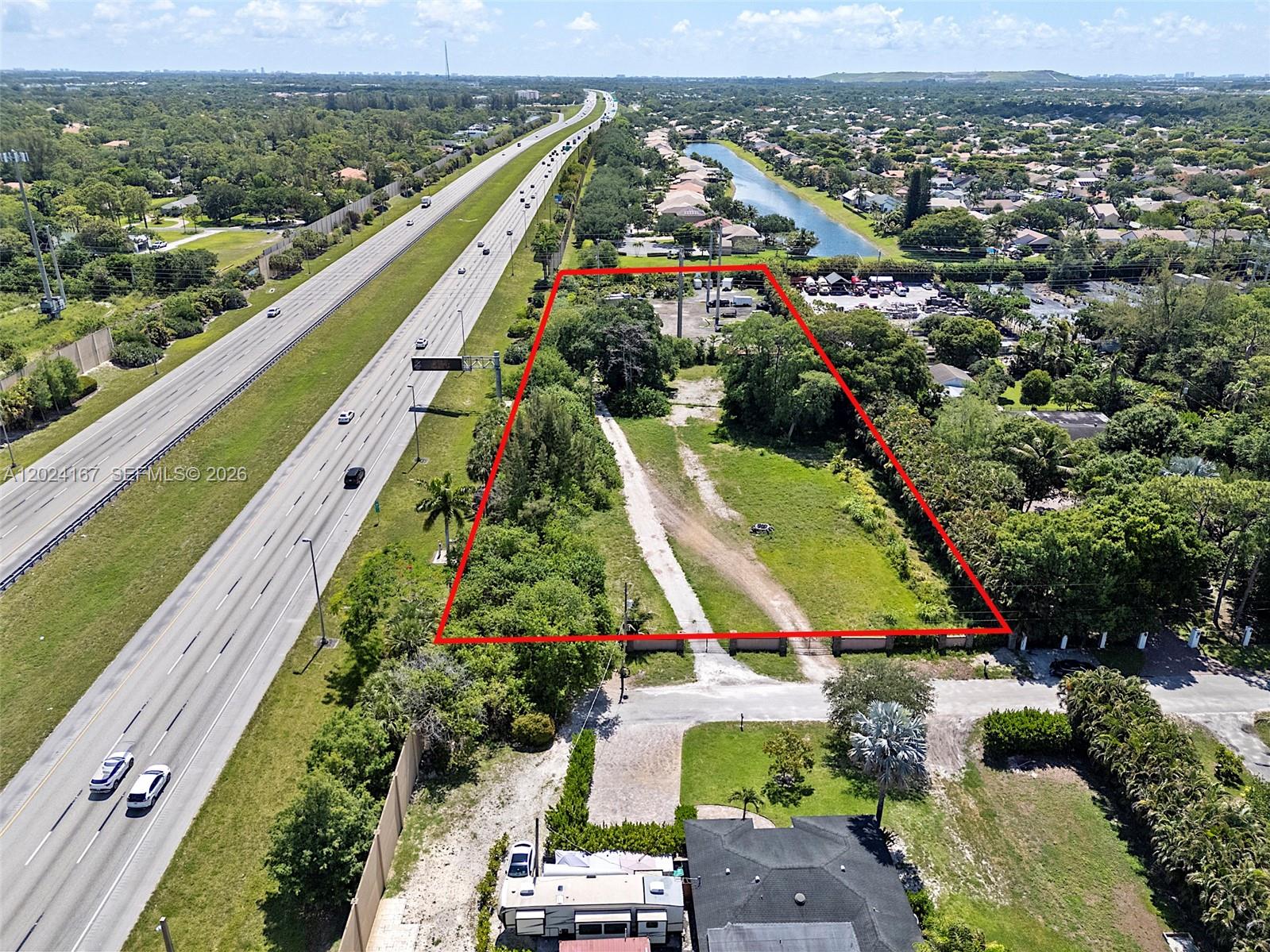 An aerial view shows a vacant, rectangular lot outlined in red next to a highway — 5680 Pinetree Rd, Parkland FL 33067, PARKLAND, FL