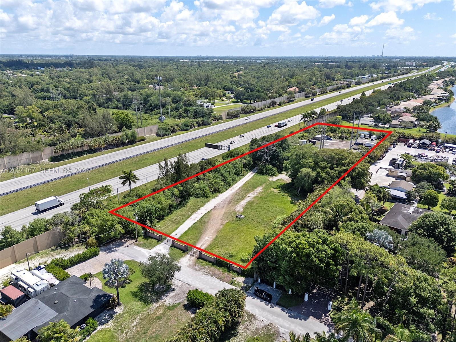 An aerial view shows a rectangular vacant lot outlined in red next to a highway — 5680 Pinetree Rd, Parkland FL 33067, PARKLAND, FL