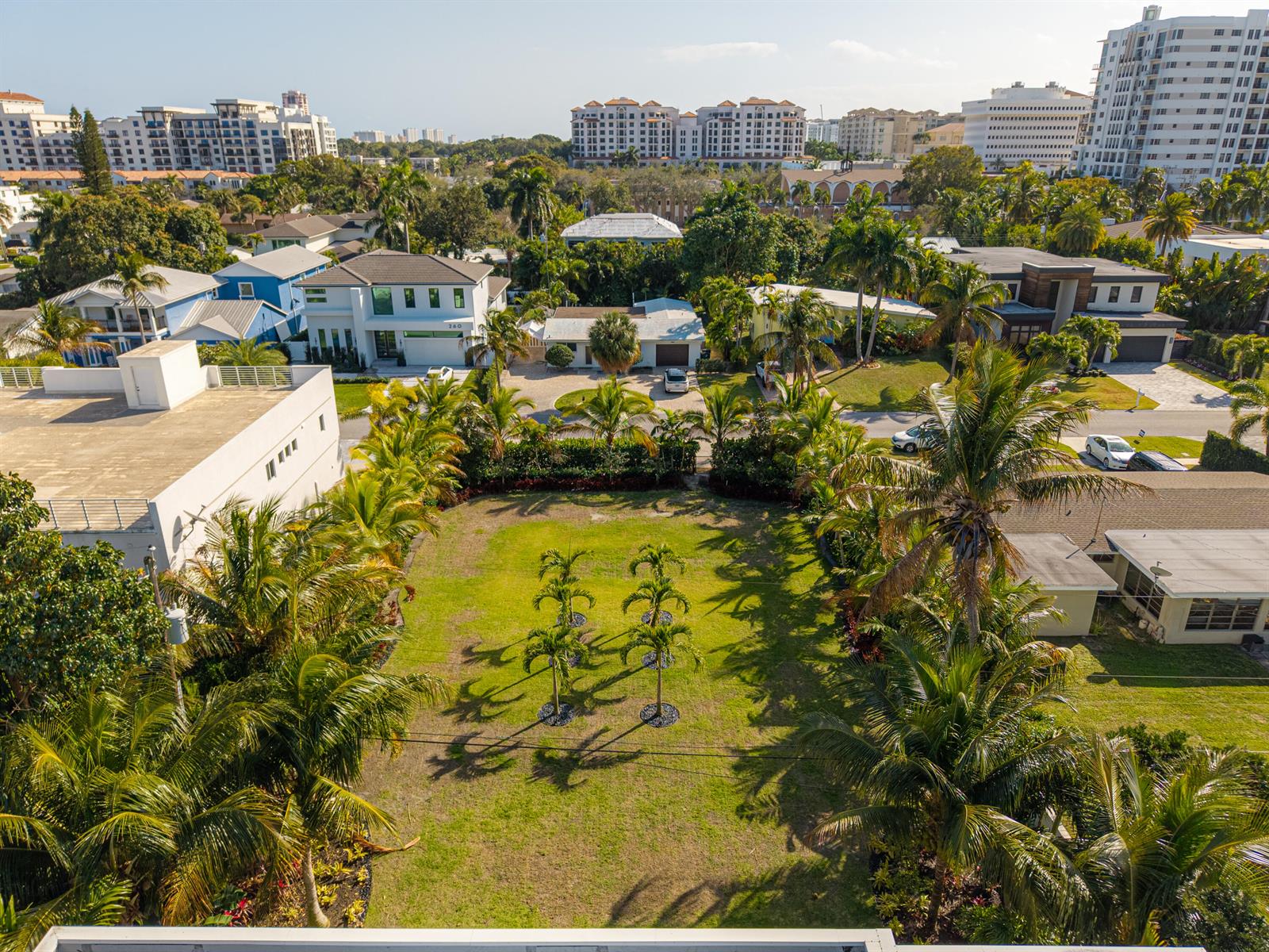 An aerial view shows a rectangular grassy lot surrounded by palm trees and residential buildings — 255 NE 3rd Street, Boca Raton FL 33432, BOCA RATON, FL