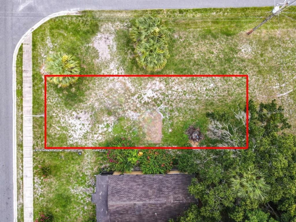An aerial view shows a rectangular vacant lot outlined in red next to a house — 939 MOTON AVENUE, SANFORD, FL