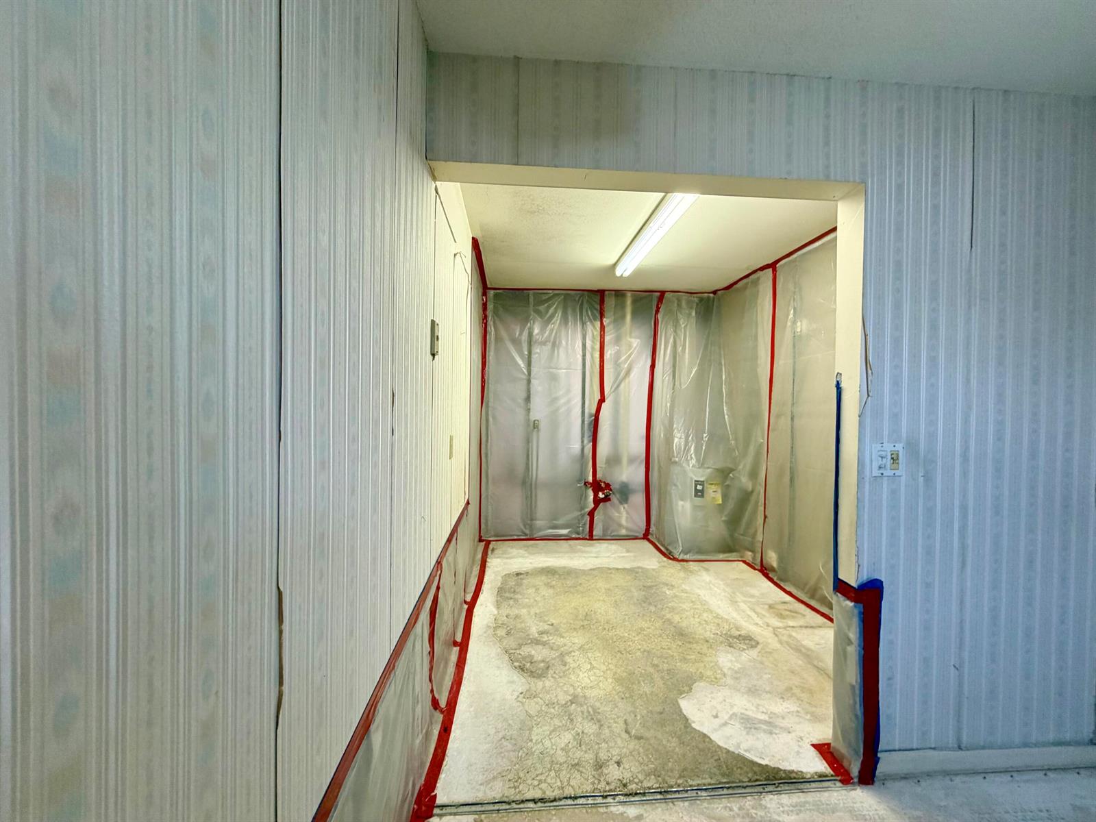 A room under renovation features plastic sheeting on the walls and an exposed concrete floor — 55 Hastings D, West Palm Beach FL 33417, WEST PALM BEACH, FL