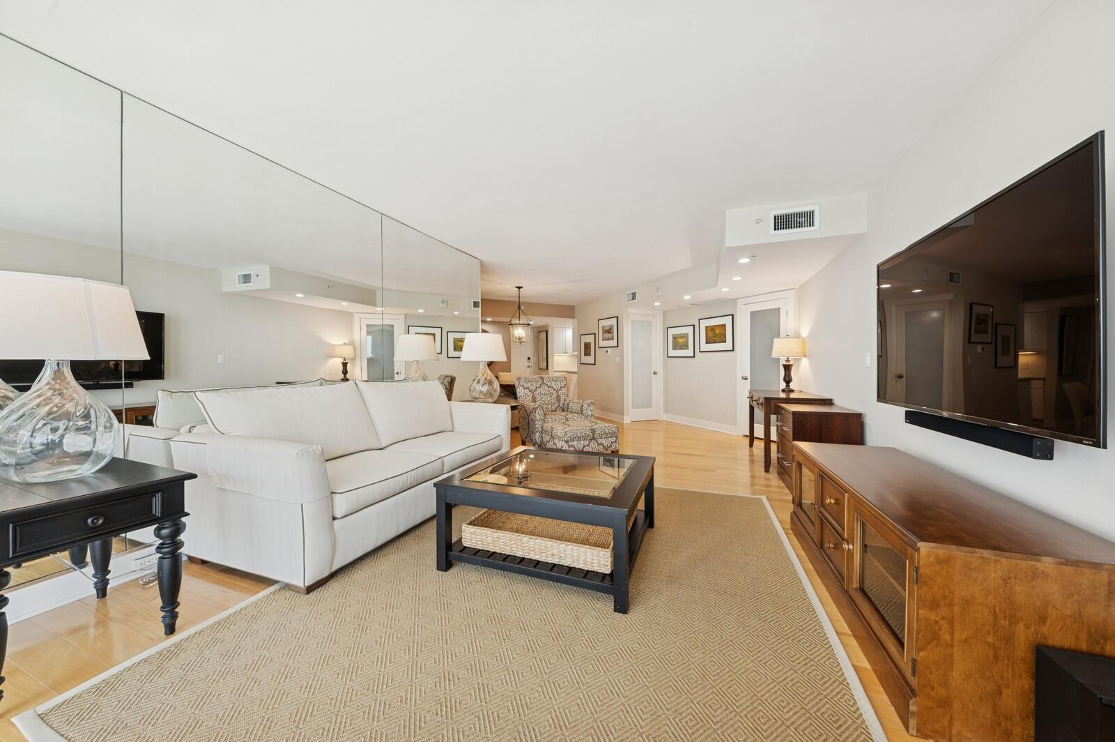 A living room features a white sofa, a coffee table, and a large wall mirror — 3000 N Ocean Drive # G, Singer Island FL 33404, SINGER ISLAND, FL
