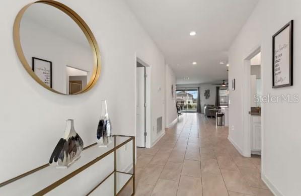 A bright hallway features light tile flooring, a gold-rimmed mirror, and a glass console table — 9298 SOMMERSET HILLS DRIVE, DAVENPORT, FL