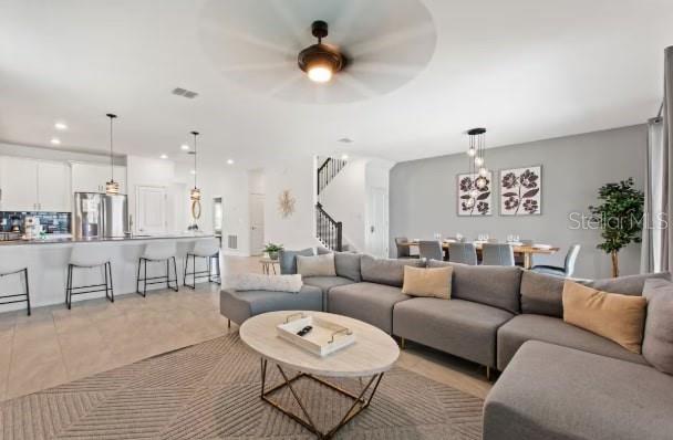 An open-concept living room features a large gray sectional sofa, dining area, and kitchen island — 9298 SOMMERSET HILLS DRIVE, DAVENPORT, FL