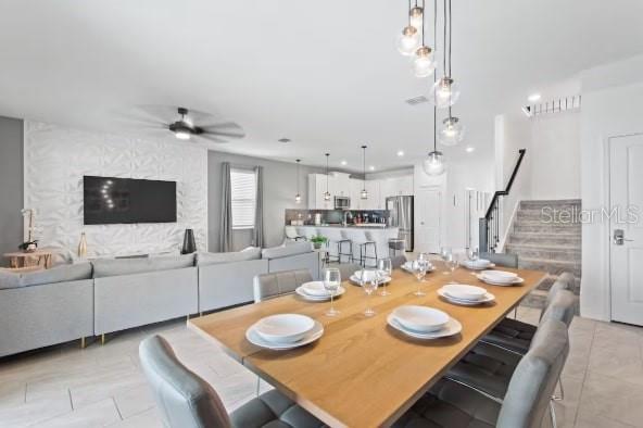 An open-concept living and dining area features a textured accent wall and modern light fixtures — 9298 SOMMERSET HILLS DRIVE, DAVENPORT, FL