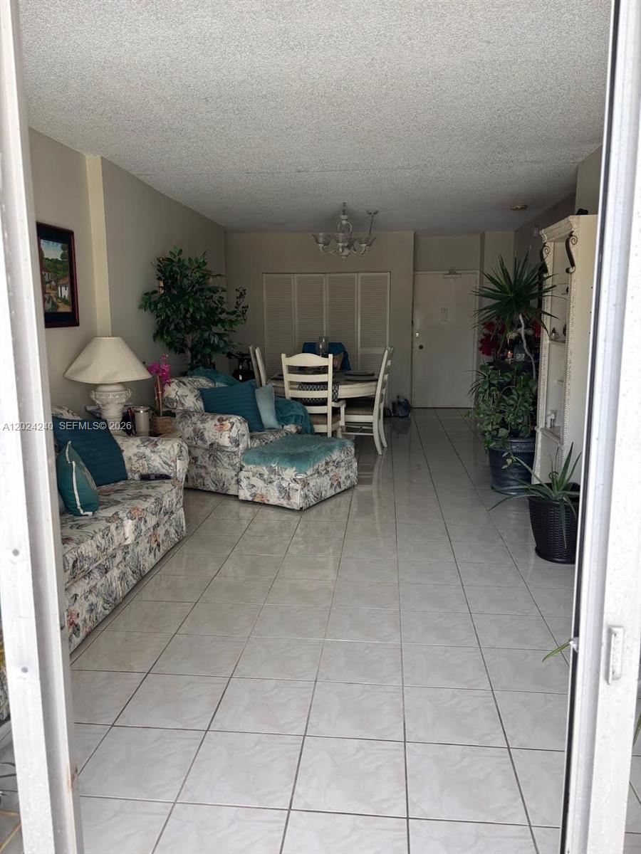 A living and dining area features tiled floors, floral furniture, and a white dining set — 1985 S Ocean Dr # 3B, Hallandale Beach FL 33009, HALLANDALE BEACH, FL