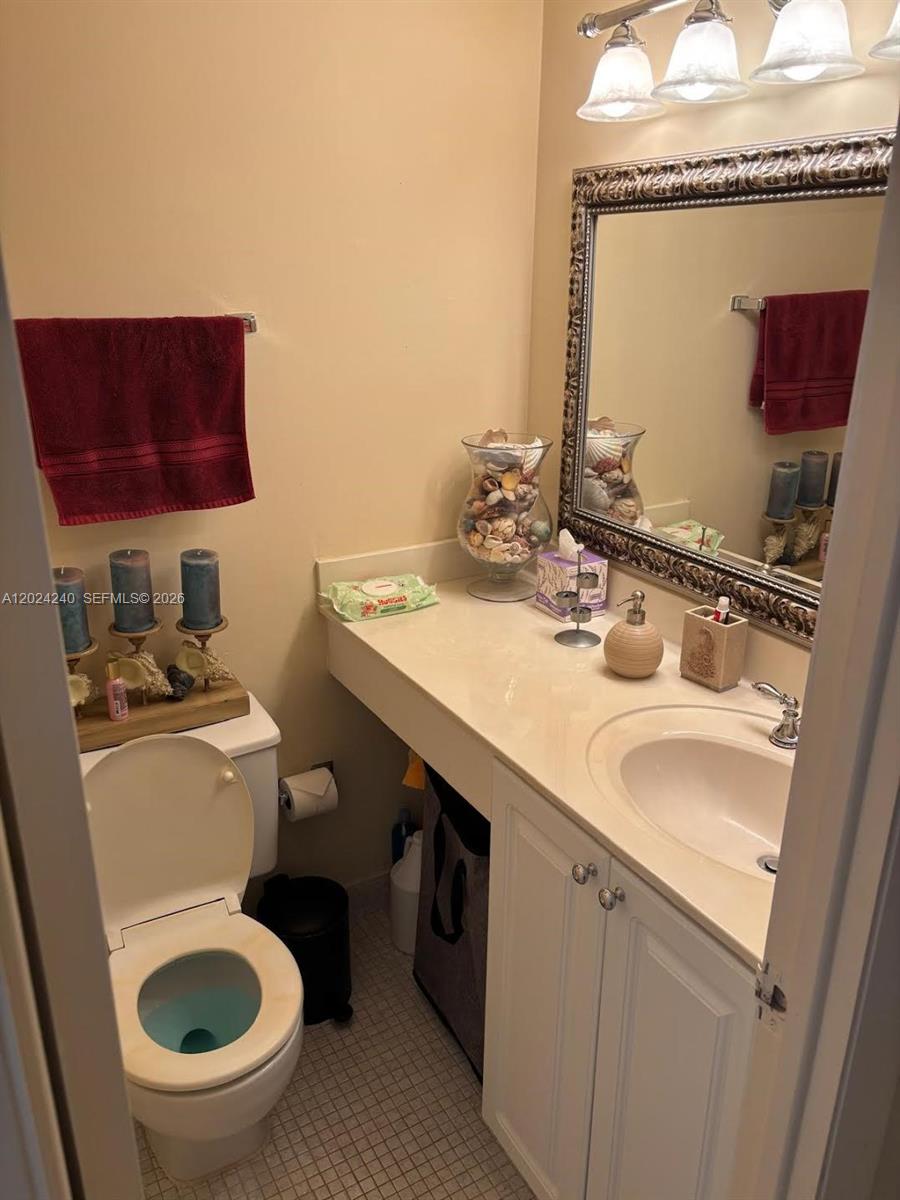 A bathroom features a vanity with a white countertop, a mirror, and a toilet — 1985 S Ocean Dr # 3B, Hallandale Beach FL 33009, HALLANDALE BEACH, FL