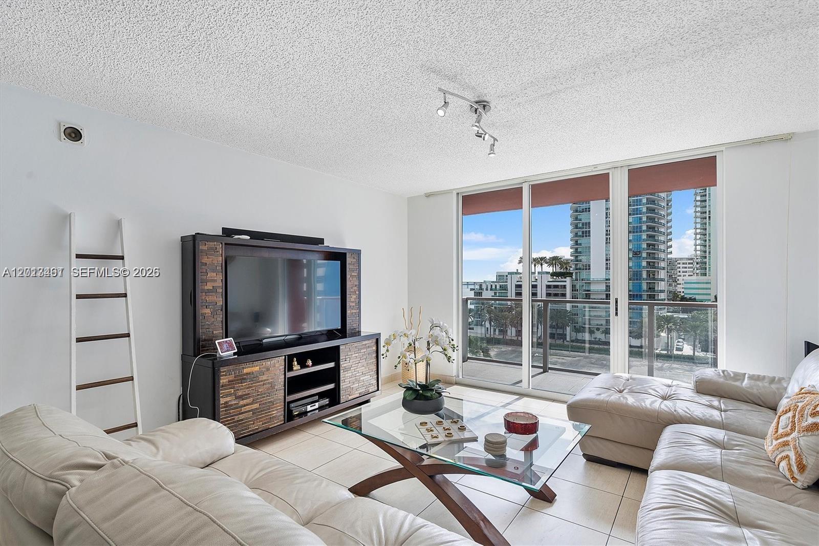 A living room features a glass coffee table, leather sofas, and a balcony with city views — 1155 Brickell Bay Dr # 603, Miami FL 33131, MIAMI, FL