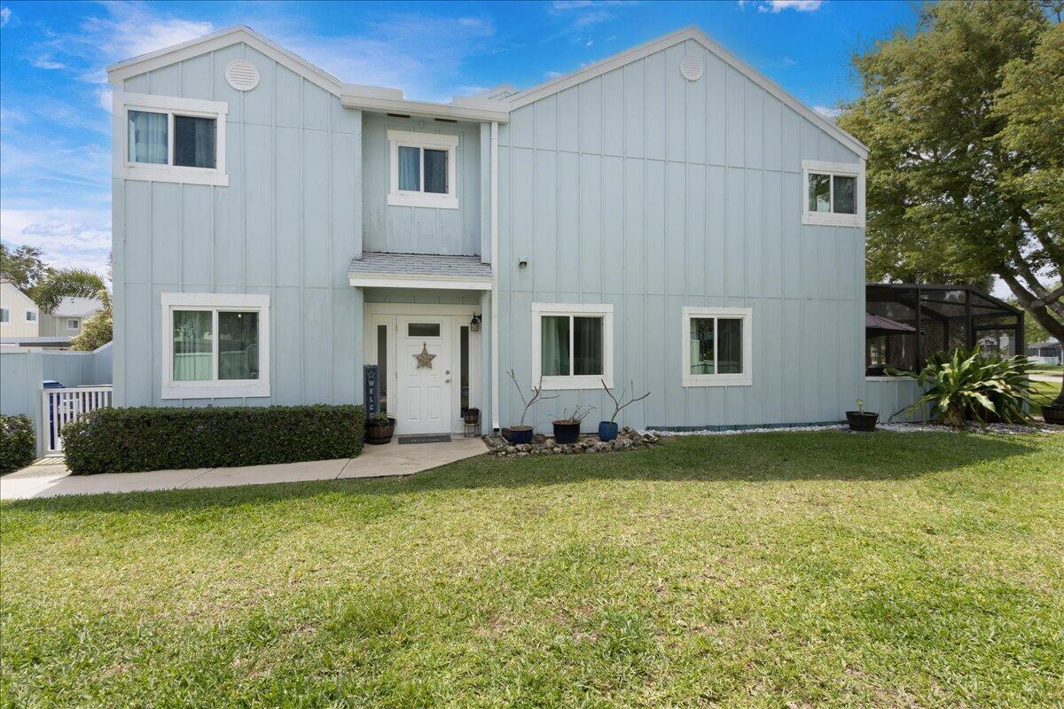 A two-story light blue house with vertical siding, a white front door, and a lawn — 6198 Riverwalk Lane # 1, Jupiter FL 33458, JUPITER, FL