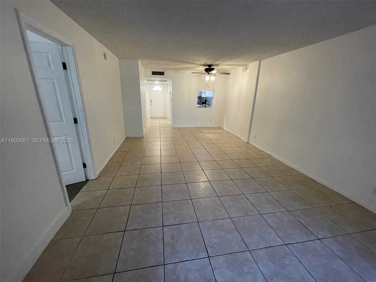 An empty room with beige tile flooring, white walls, and a ceiling fan — 4500 N Federal Hwy # 102A, Lighthouse Point FL 33064, LIGHTHOUSE POINT, FL