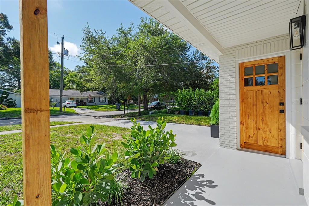 A view from a covered porch looking out toward a street with trees and houses — 6504 N 20TH STREET, TAMPA, FL