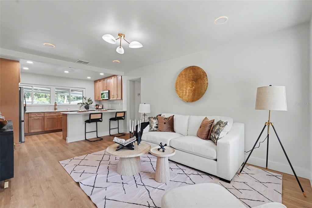A living room with a white sofa, two round coffee tables, and an open kitchen — 6504 N 20TH STREET, TAMPA, FL