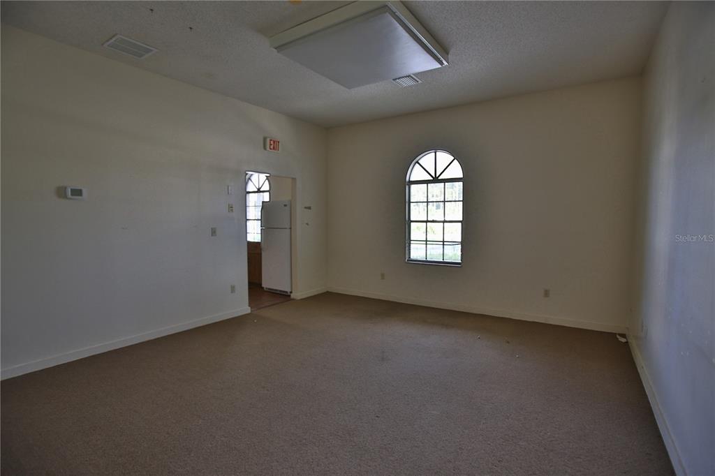 An interior view of a vacant bank lobby featuring a long wooden teller counter — 5431 E SILVER SPRINGS BOULEVARD UNIT A, SILVER SPRINGS, FL