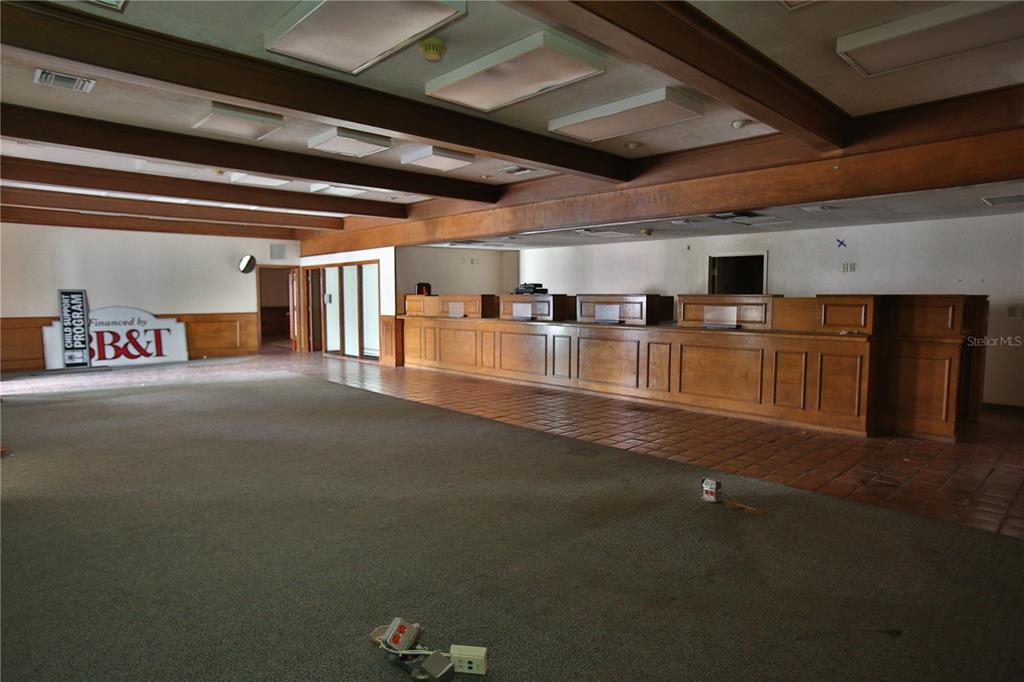 An office room features wood-paneled wainscoting, a coffered ceiling with recessed lighting, and beige carpeting — 5431 E SILVER SPRINGS BOULEVARD UNIT A, SILVER SPRINGS, FL